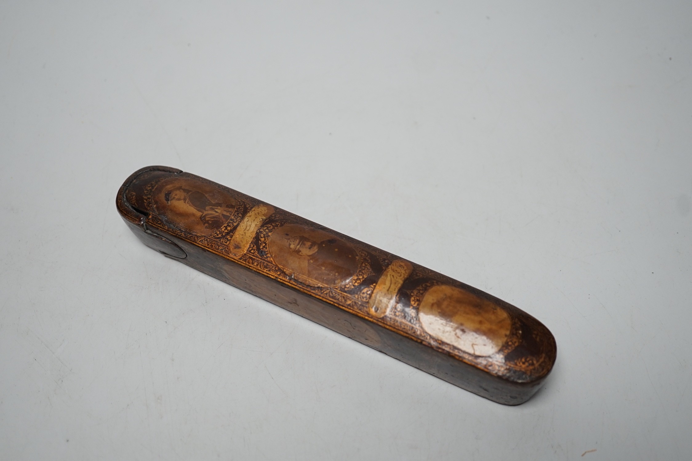 A 19th century Persian lacquered pen tray with later applied German portraits, total length 20cm